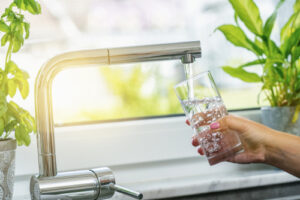 Water and Energy Systems Person Filling Up a Glass With Water