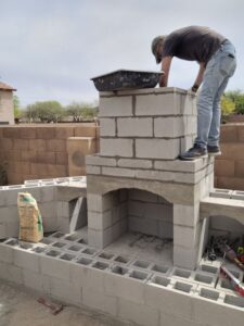 Man building outdoor fireplace chimney