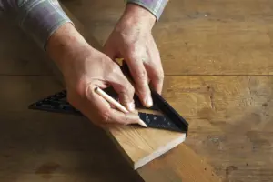 Man measuring wood to cut DIY Wooden Frames