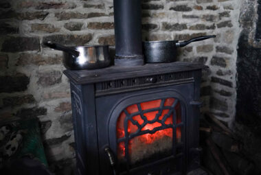 cast iron wood burning stove with pots and pans
